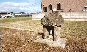 田んぼの前に建立された乳神を祀る石造りの小祠の写真