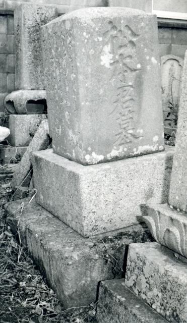 江戸時代に多度津で私塾を開いた松本直之のやや左に傾いた墓碑のモノクロ写真