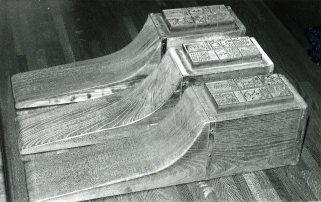 滑り台のような形をし上部に版木が付いている多度津藩札の刷台三組を縦に並べたモノクロ写真