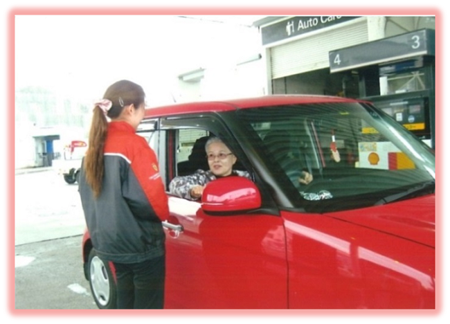 讃備石油で店員が赤色の車に乗ったお客と話している様子の写真