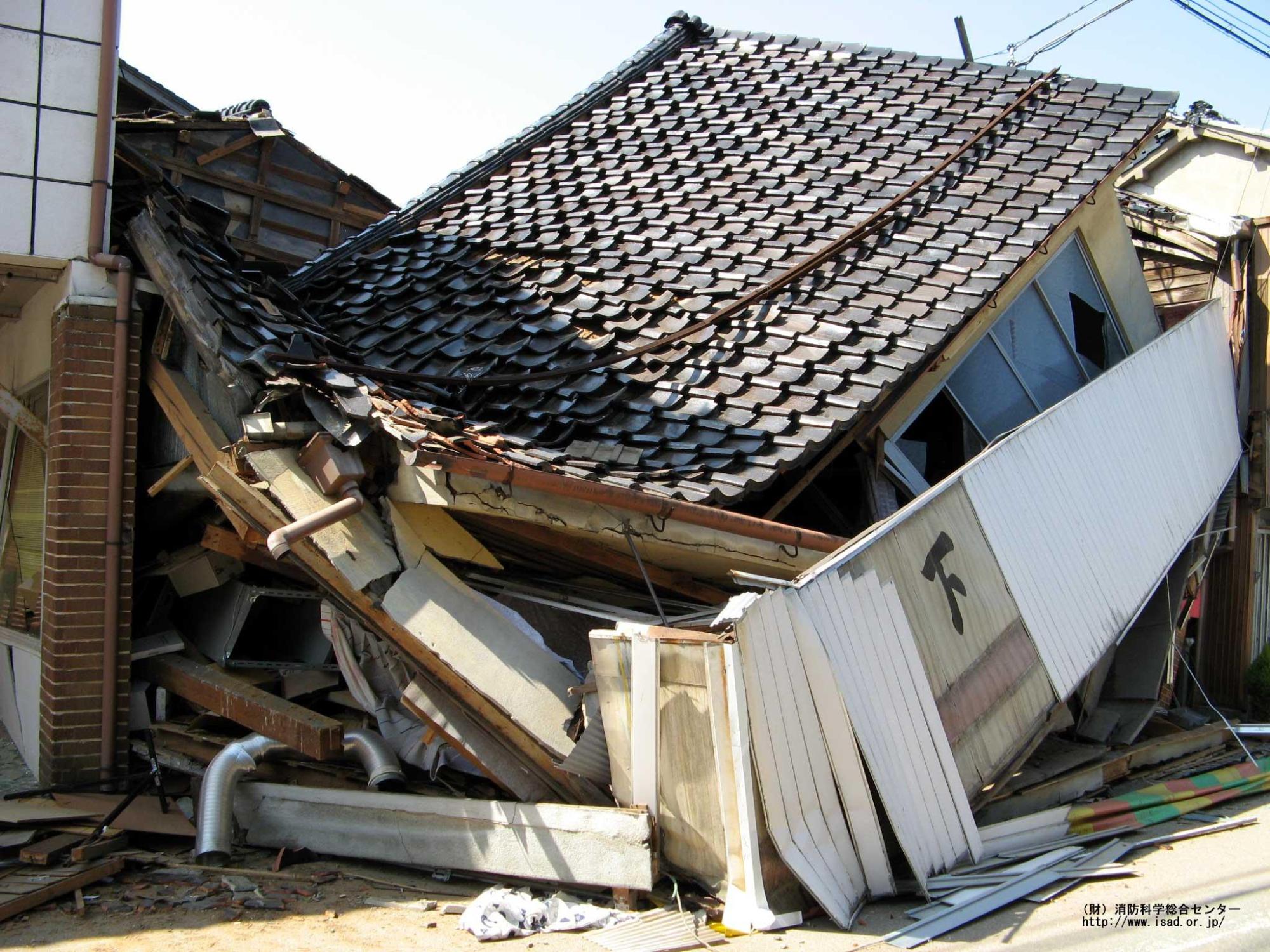地震により柱が倒れ全壊した家を写した写真